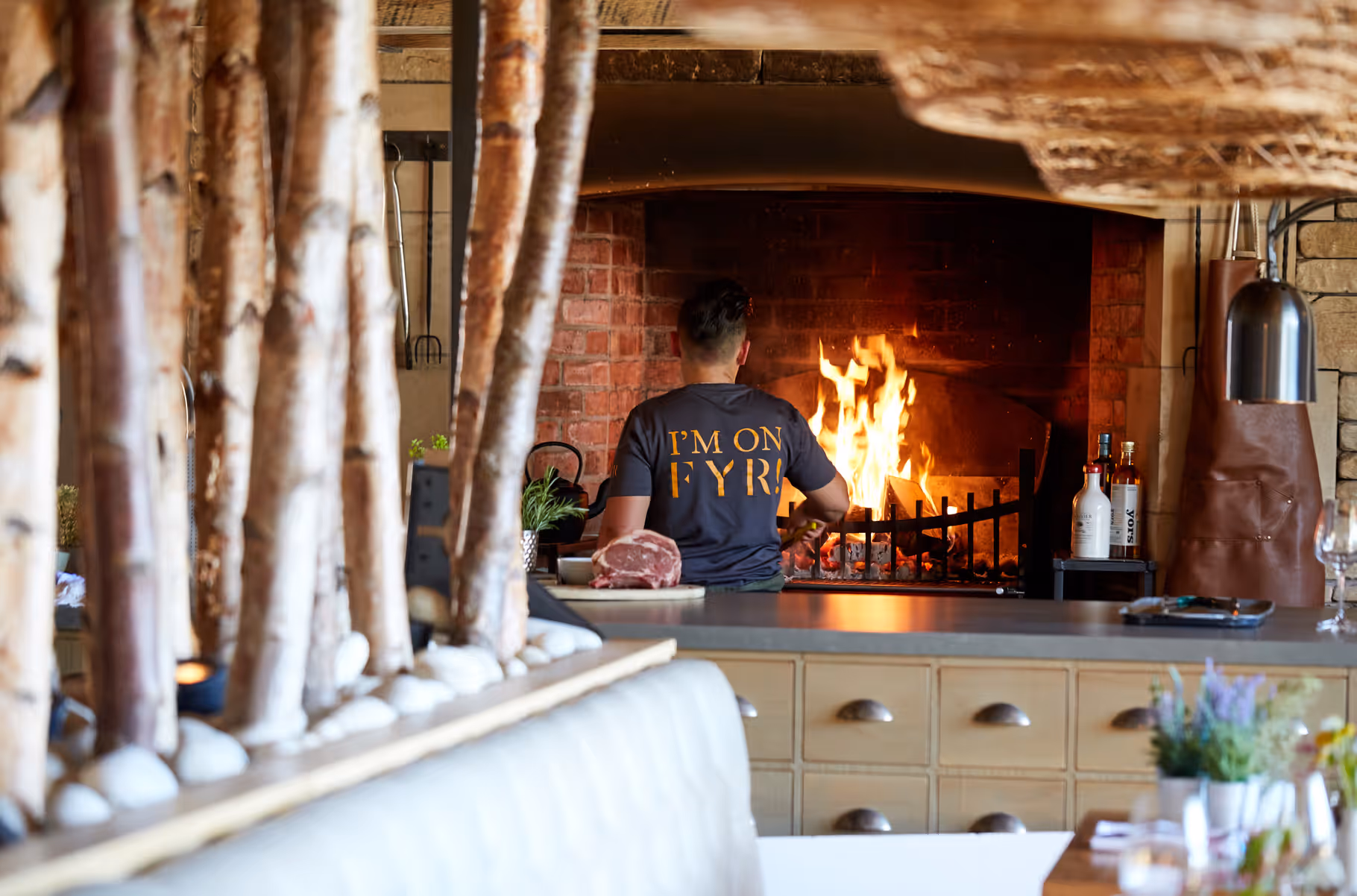 chef cooking on open fire at the fyr restaurant at north lakes, penrith