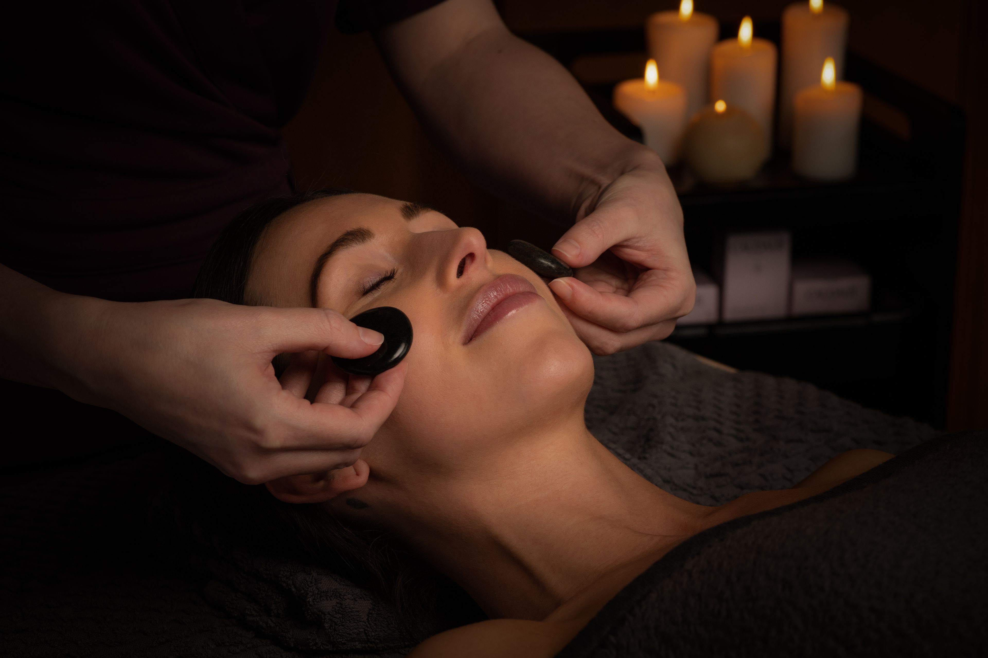 A woman receiving a hot rock facial