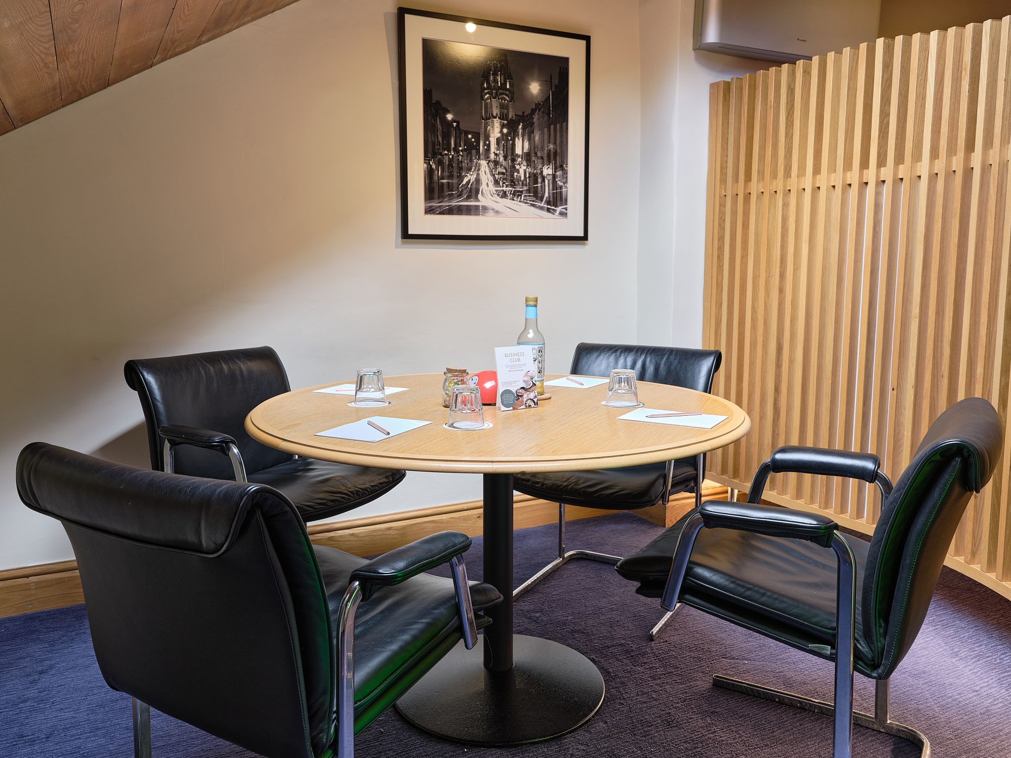 A small meeting room with a round table and four chairs