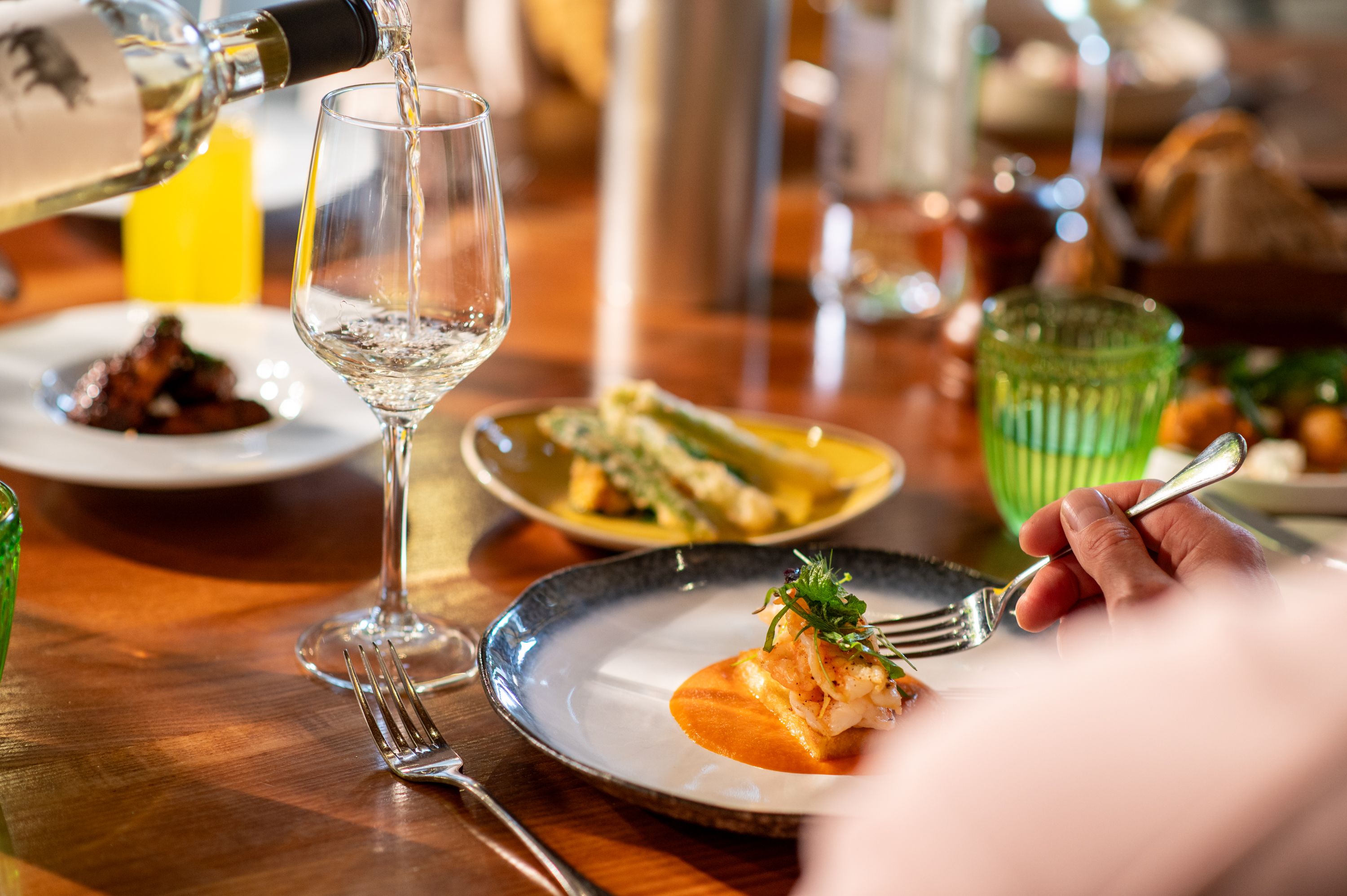 Someone eating a meal with wine